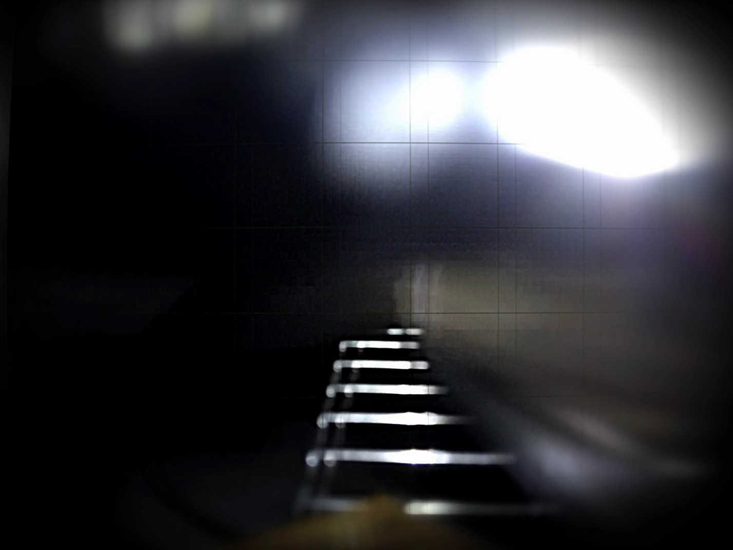 A sequence of illuminated steps recedes into darkness beneath a faint measurement grid.