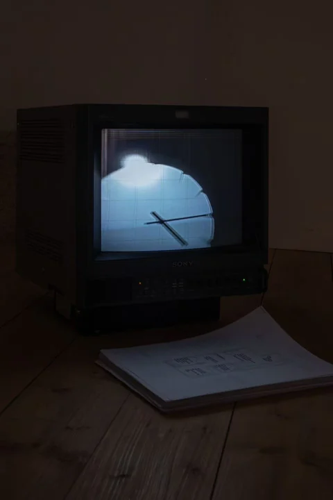 Portrait view of the CRT television and paper on the floor.