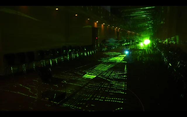 Green beams of light cross a darkened interior.