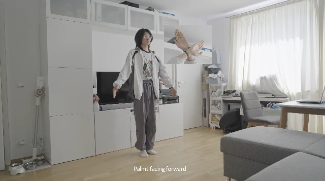 A calisthenic gesture performed in a domestic interior.