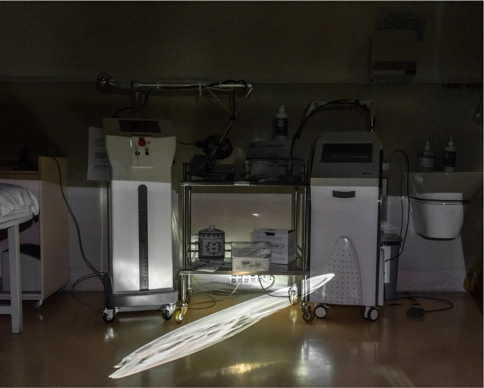 A distorted skeletal projection lies across medical equipment and the floor of a room.