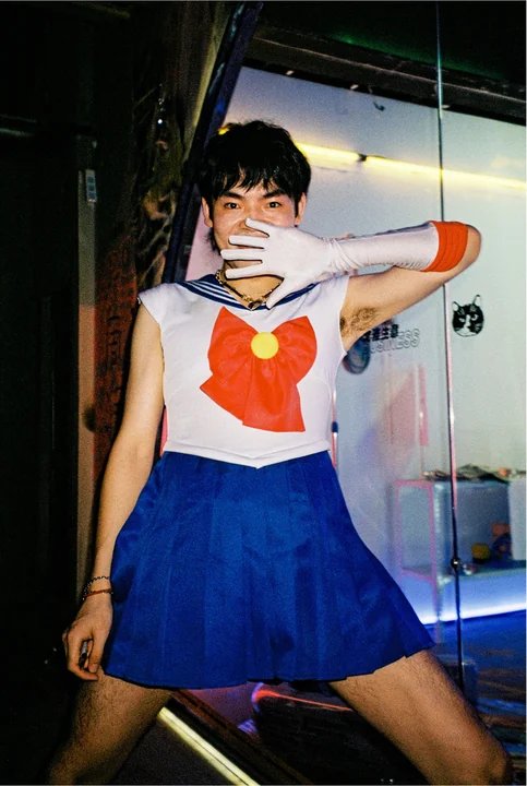 A person in a Sailor Moon costume poses in a doorway.