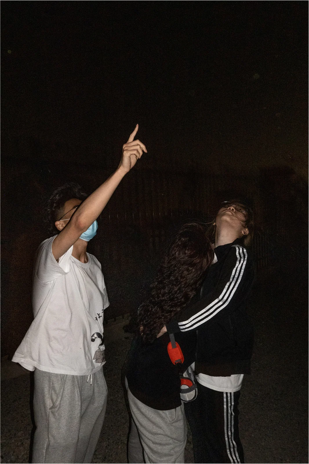 A small group look and point upwards into the night.